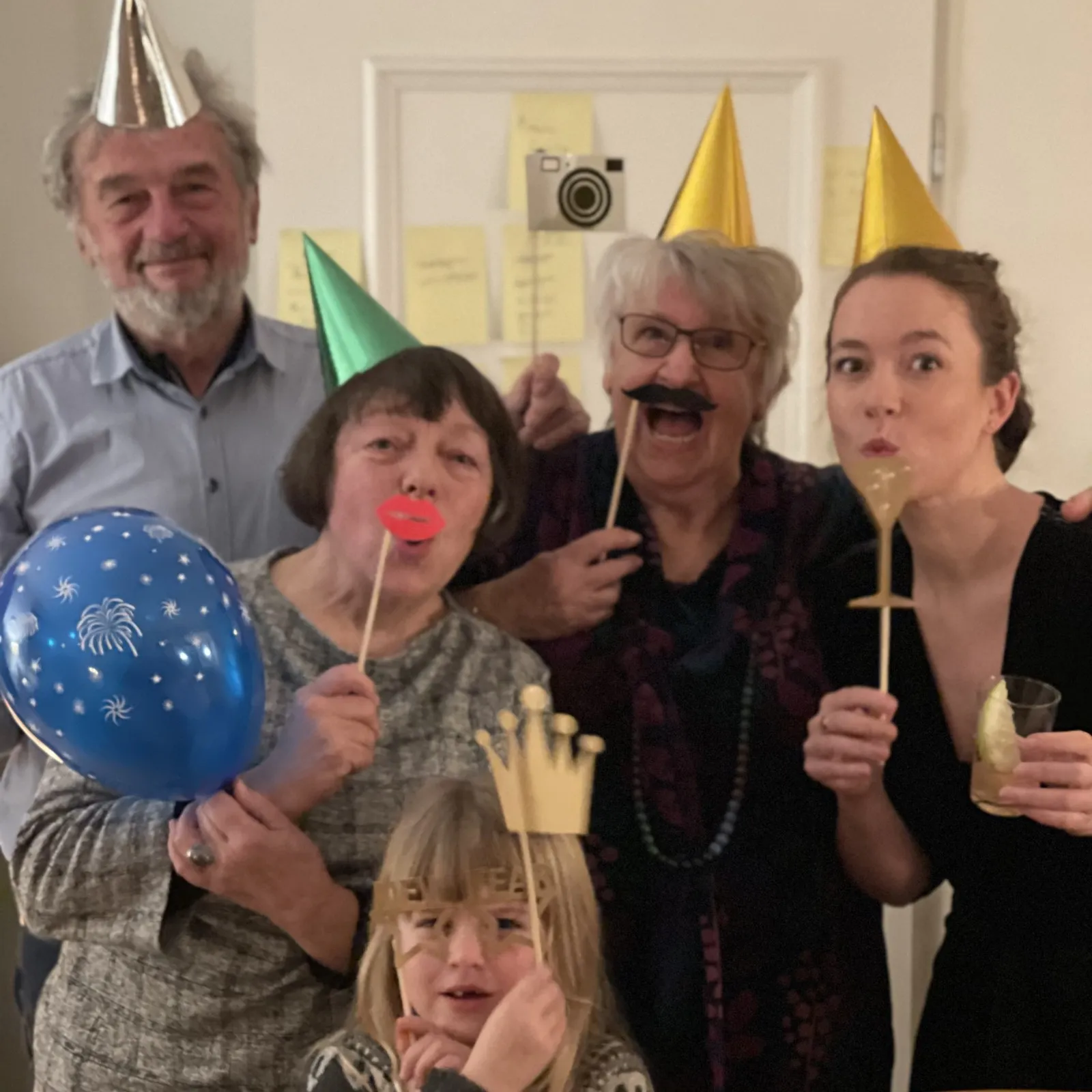 Bärbel mit Familie und Freunden bei einer Feier, mit Partyhüten und Fotorequisiten