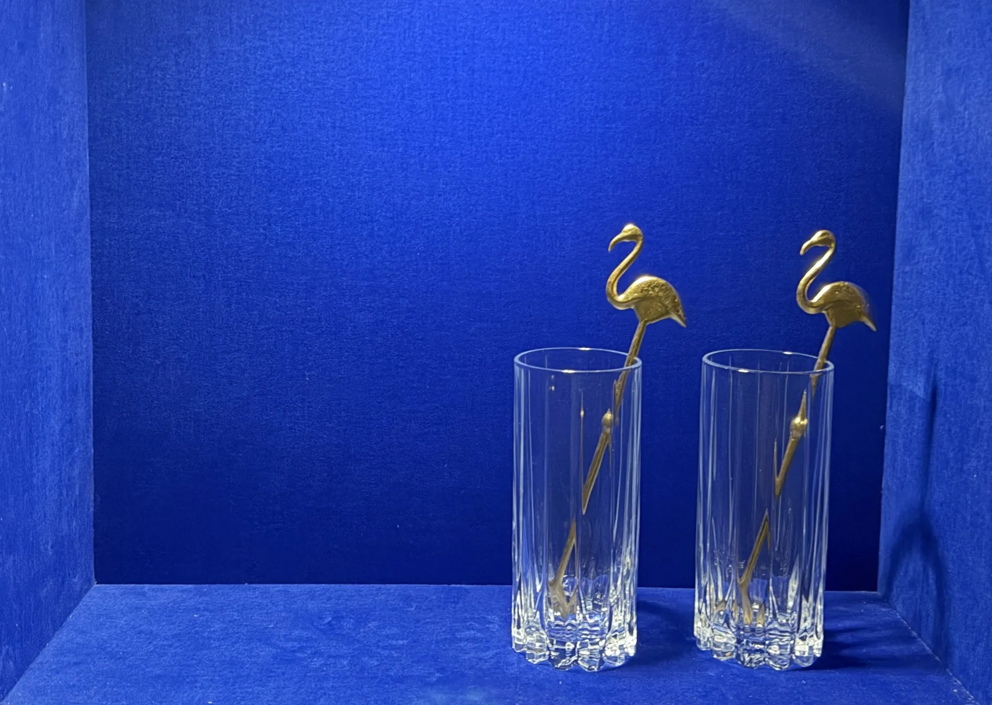 Zwei Highball-Gläser mit vergoldeten Flamingo-Rührern in der blauen Samtvitrine, HR-PC-10 Schnapsidee