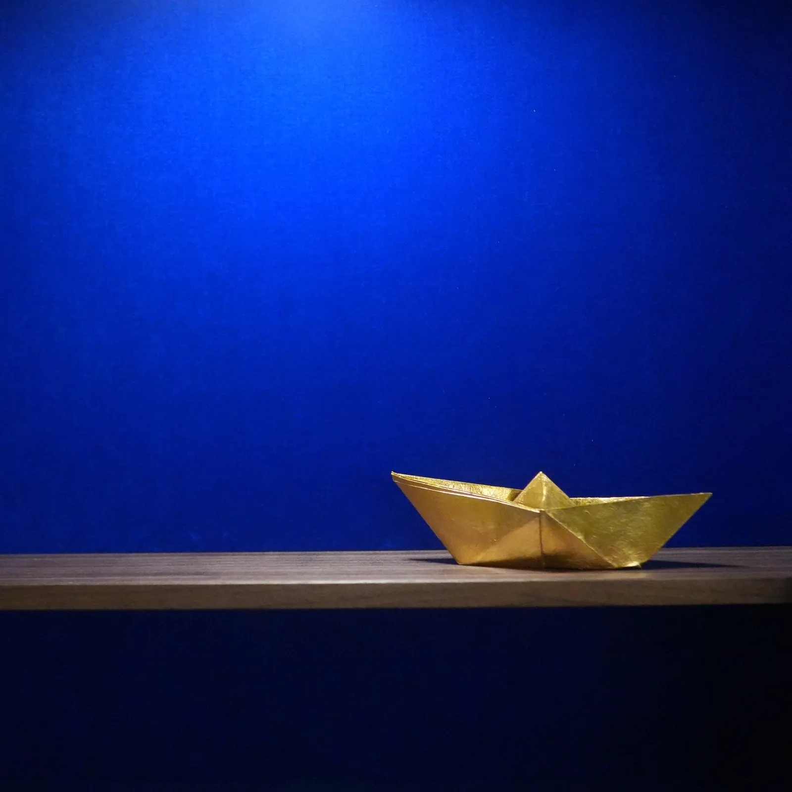 Das goldene Papierschiffchen, HR-PC-01, auf Walnuss vor blauem Samt