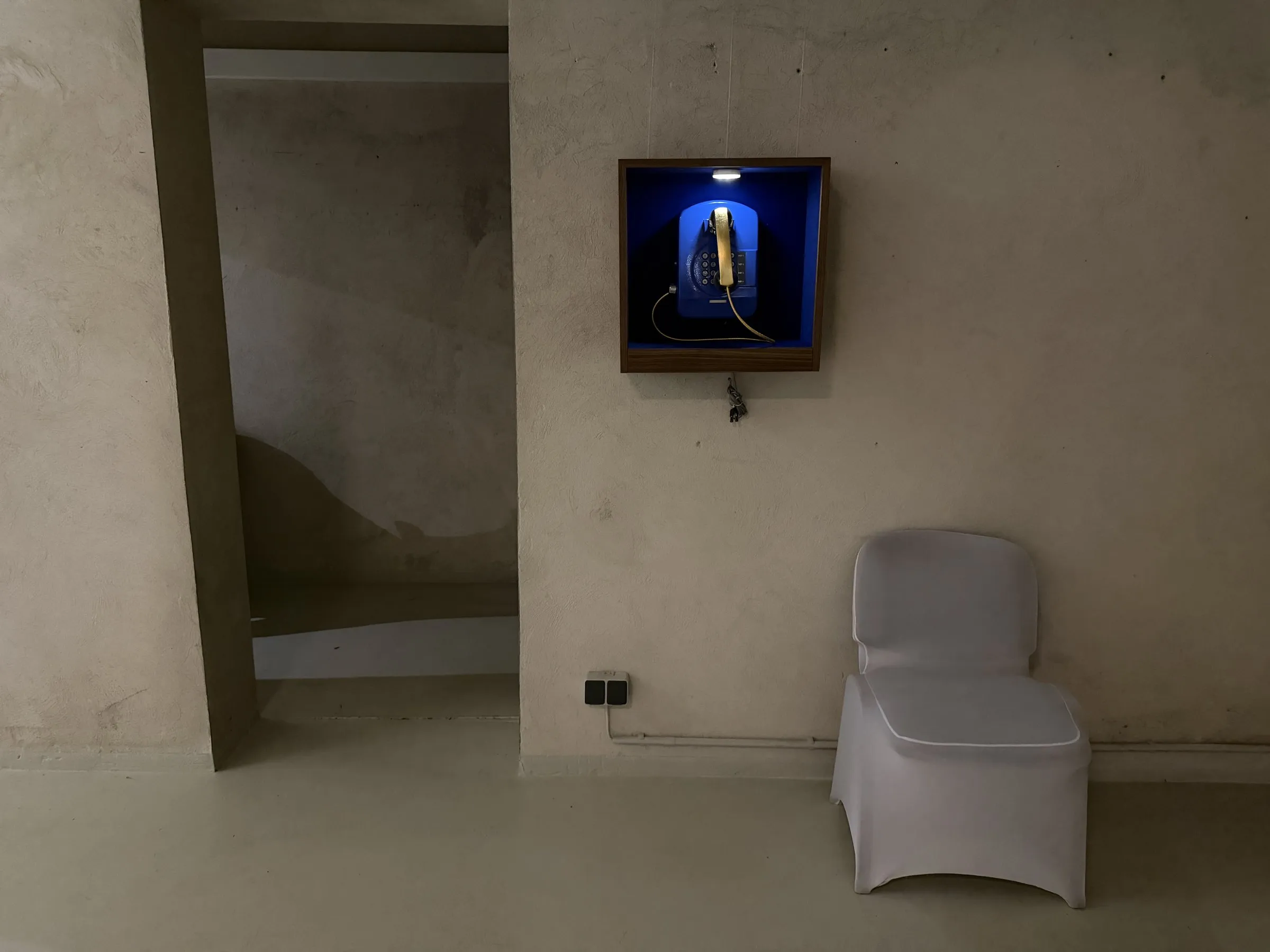 Vitrine an der Wand im Bunker West, mit Stuhl